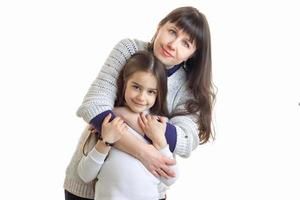 la joven madre abraza a su pequeño brazo y a su linda hija foto
