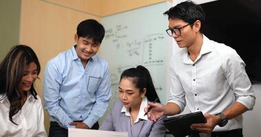 Handheld shot, Group of Asian Young workers having brainstorm during business meeting in office, Business colleagues meeting and discussing project together, teamwork meeting concept video