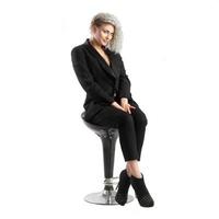 blonde with curly hair sits on chair photo