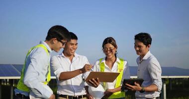 grupo del equipo de ingeniería asiático que se reunió para planificar la verificación del funcionamiento del panel solar solar y fotovoltaico en la estación, jóvenes ingenieros inspectores hombres y colega femenina planificación de la operación video