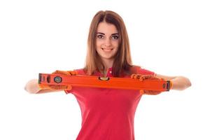 portrait of young happy brunette builder girl makes renovation isolated on white background photo