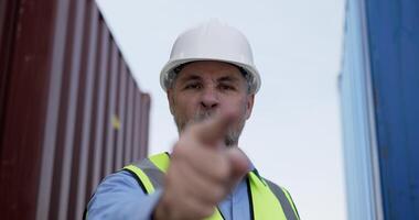 ritratto di mezza età caucasico attività commerciale manager uomo è incolpando con lunatico, punto dito e guardare per telecamera nel spedizione porta, problema nel la logistica mezzi di trasporto concetto. video