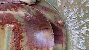 Hole or hole, armor deformation from a projectile close-up. Damaged armor of a Russian armored personnel carrier by shell fragments. War in Ukraine. Russian combat vehicle with holes in the armor.