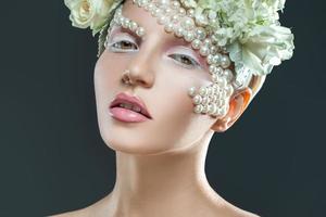 sweet young woman with tender pink and white makeup looking at camera photo