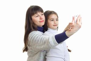 mamá con su pequeña hija hace una foto por teléfono y sonríe