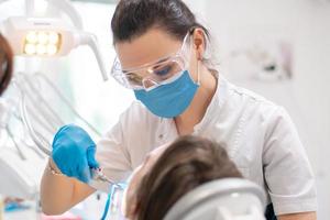 dentista trata los dientes a una niña en una clínica