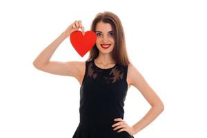 young happy brunette lady with red heart in hands smiling on camera isolated on white background. Valentines Day concept. photo