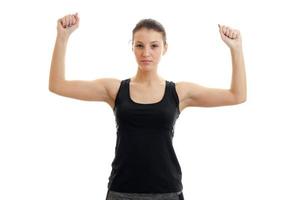 Serious young girl in sports uniform with hands in the air looking at the camera photo