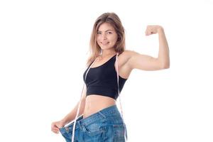 athletic girl in black top and the big jeans shows biceps on his arm  smiling photo