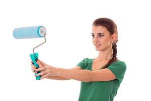 a young girl stands sideways and stretched in the hands of the roller for painting walls close-up isolated on white background photo