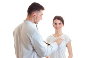 the doctor listens to the heart with a stethoscope from a young girl isolated on a white background photo