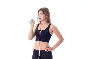 athletic girl holding a bottle and going to drink some water photo