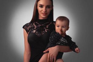 Sexy young mother with little baby girl in studio photo