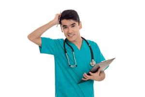 joven médico sosteniendo una tableta y un estetoscopio sobre los hombros de aislado sobre fondo blanco. foto