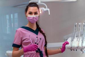 dentis en uniforme rosa en la clínica foto