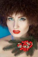 beautiful girl in a fur hat and a Christmas tree on neck photo