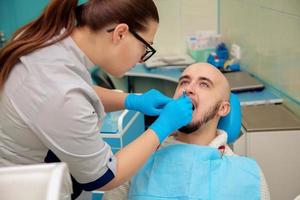 Picture of beautiful male model on cheking teeth in dental office photo