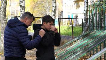 padre e hijo, entrenamiento crossfit en el patio de recreo video