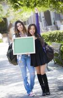 Excited Mixed Race Female Students Holding Blank Chalkboard photo