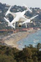 sistema de aviones no tripulados quadcopter drone en el aire sobre la costa del océano. foto