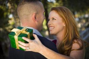 Beautiful Woman and Handsome Military Man Exchange Christmas Gift photo