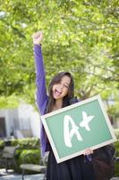 Mixed Race Female Student Holding Chalkboard With A plus Written photo