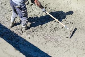 Pool Construction Worker Working With A Bullfloat On Wet Concrete photo