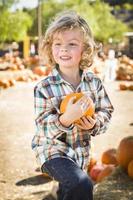 Little Boy Holding His Pumpkin at a Pumpkin Patch photo