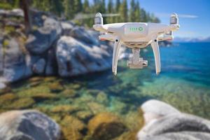 Back of Unmanned Aircraft System Quadcopter Drone Flying Above Lake Tahoe photo