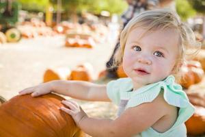 Adorable Baby Girl Having Fun at the Pumpkin Patch photo