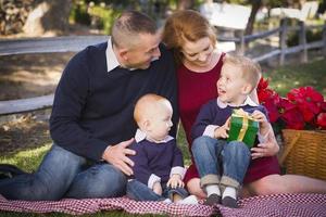 Small Young Family Opening Christmas Gifts in the Park photo