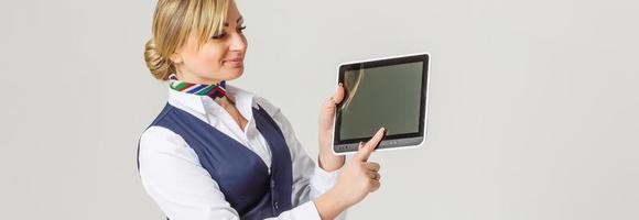 Charming Stewardess Dressed In Blue Uniform with empty blank in hands photo