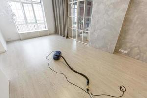 Cleaning of the apartment. Vacuum cleaner on the floor photo