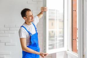 Construction worker installing new window in house photo