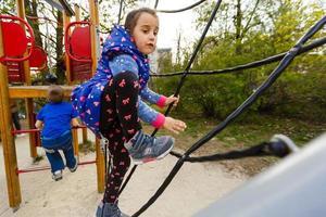 attractive little girl on outdoor playground equipment photo