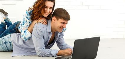 Couple buying online together with a laptop on a desktop at home photo