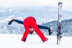 Girl in the snow upside down in a ski suit photo