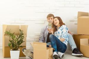 Smiling couple leaning on boxes in new home photo