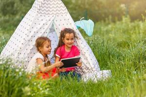 children playing in tablet pc in a tent photo