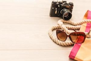 Flat lay traveler accessories on yellow background with palm leaf, camera and sunglasses. Top view travel or vacation concept. Summer background photo