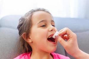 mother's hand helps to pull out a tooth daughter photo