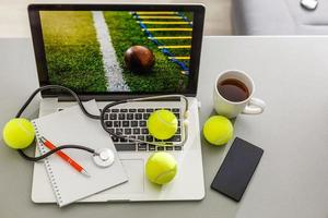 Sports tennis player with racket in blue costume. Woman atlete. Laptop on the table with design for bookmaker advertising photo