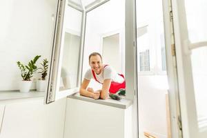 Construction worker installing window in house photo