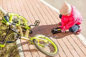 inflating a tyre of her bicycle, closeup shot photo