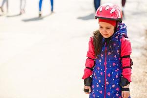 Girl with helmet on but without protective knee pads crying photo