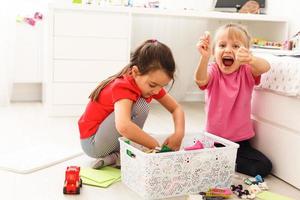 Children play with a toy designer on the floor of the children's room. Two kids playing with colorful blocks. Kindergarten educational games. photo