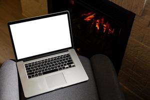 laptop and pile of books against the background of the fireplace photo
