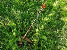 man with a manual lawn mower mows the grass photo