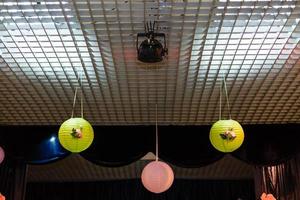 sphere shape pendant lamp. That's hanging on the ceiling with wall as a background. photo