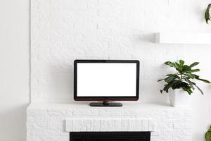 televisión puesta en una mesa de madera, pared blanca de fondo foto